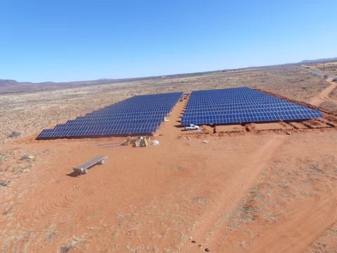 Ground-mounted solar array on open land under a clear sky