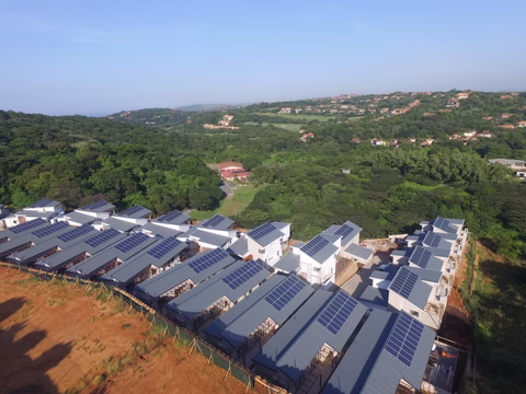 Rows of rooftop solar panels on a hillside residential complex