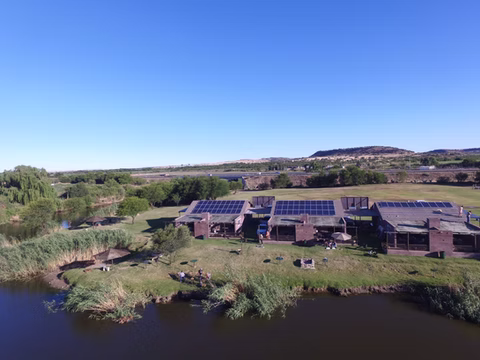 Homes with rooftop solar panels beside a river